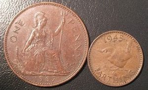 Australian coins on black background Two old Australian coins, one penny and one half penny, displayed on a black surface.