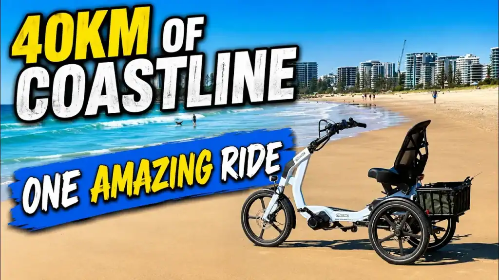 A white adult tricycle with a large basket on a sandy beachside path, perfect for seniors and disability mobility. Ideal for a scenic coastal ride.