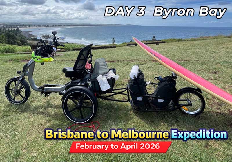 Black adult tricycle parked on grassy hill with ocean view. Senior-friendly tricycle for mobility and leisure.