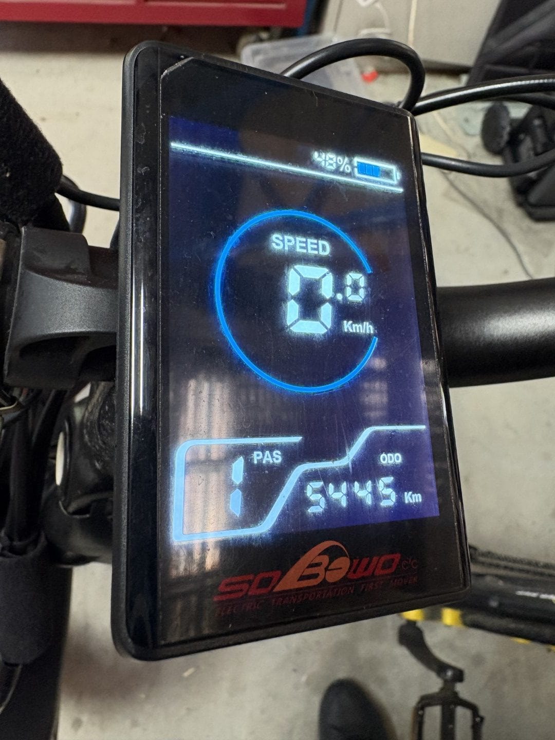 An LCD screen on an electric adult tricycle displaying speed and distance travelled. The screen shows current speed and odometer reading.