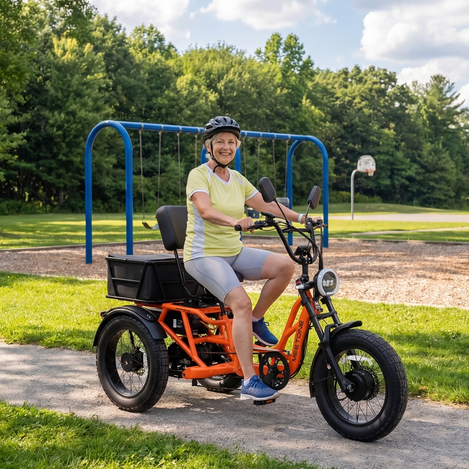 Man riding electric tricycle in a park. The tricycle has a large storage box.