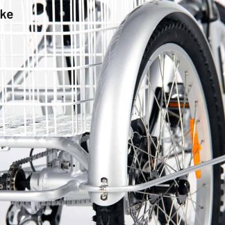 Close-up of a silver adult tricycle rear wheel with black tyre and white basket. The tricycle features a sturdy design.