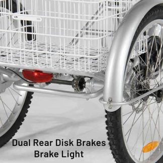 Close-up of a silver adult tricycle's rear wheel and basket, featuring dual rear disk brakes and a brake light. The tricycle has a white wire basket.